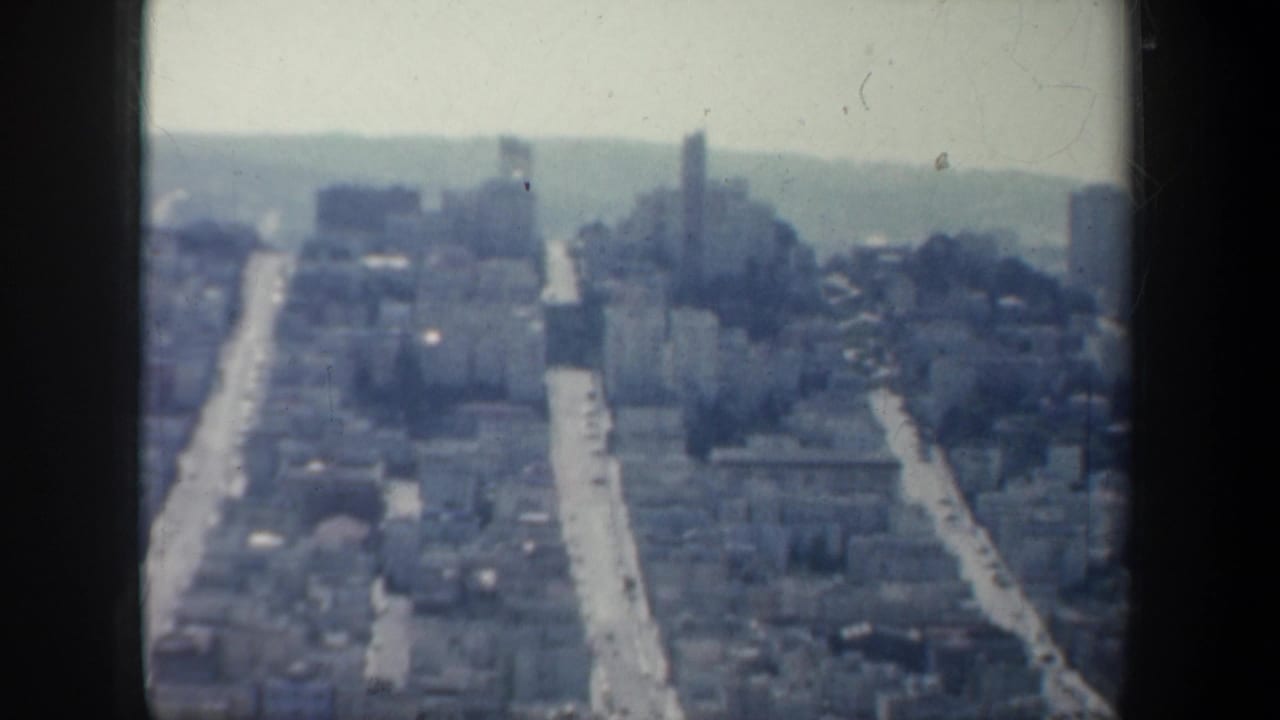 High view of San Francisco streets and buildings with a distant tower-like form.