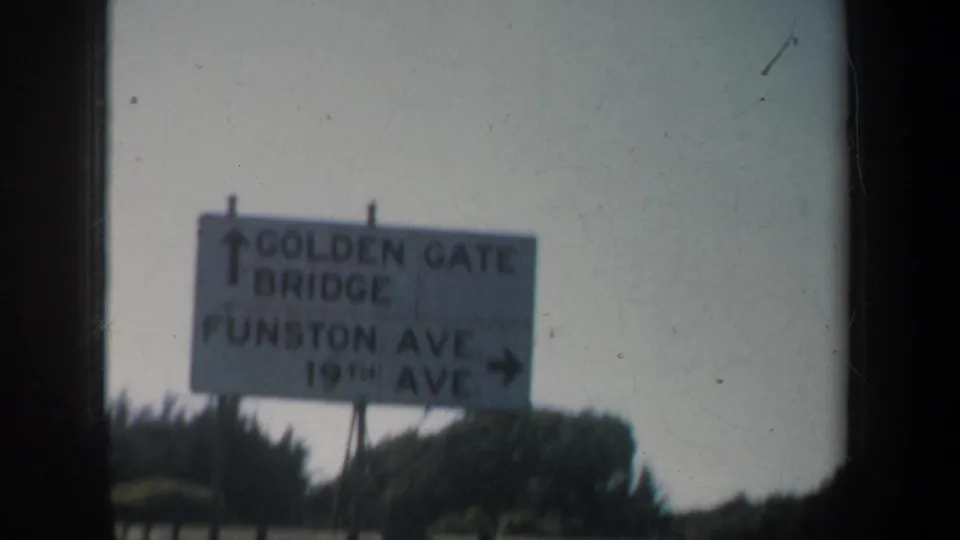 San Francisco road sign pointing toward Golden Gate Bridge, Funston Avenue, and 19th Avenue, with trees below the sign.