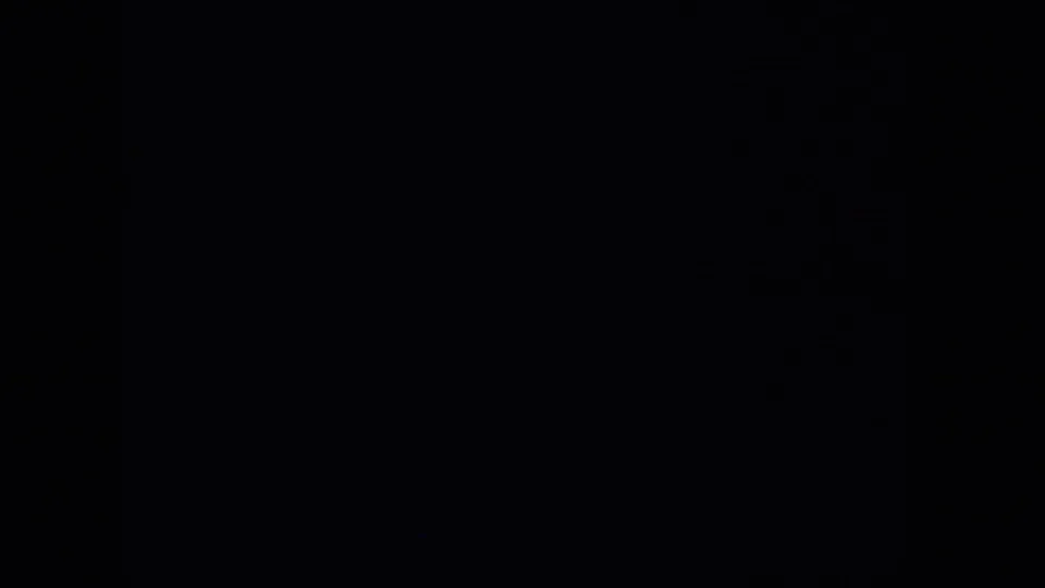 A largely black 8mm frame with only faint tonal variation, likely between visible airplane-window views.