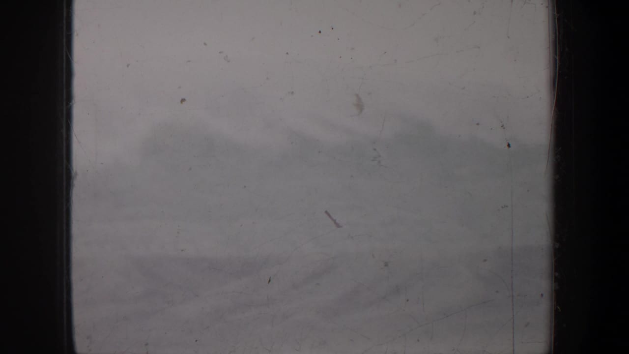 Hazy exterior view with dark film edge and scratched, dusty emulsion.