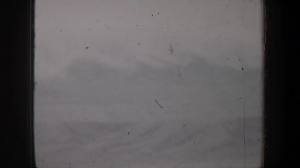 A scratched 8mm home-movie frame from the Portland, Oregon metadata shows a soft, foggy horizon with no visible people or structures.