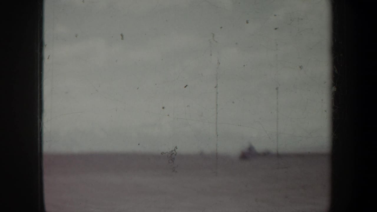 Soft, distant view of a pale horizon with a small dark shape near the upper right.