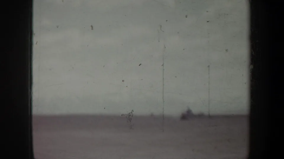 Soft 8mm view of a distant, hazy landscape or waterline with a small dark shape near the horizon.