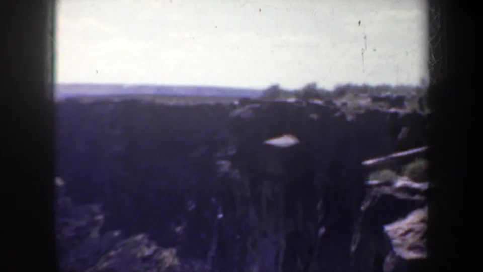 Final 8mm frame shows a darker canyon view near Portland, with the bridge receding at right and distant horizon beyond the cliffs.