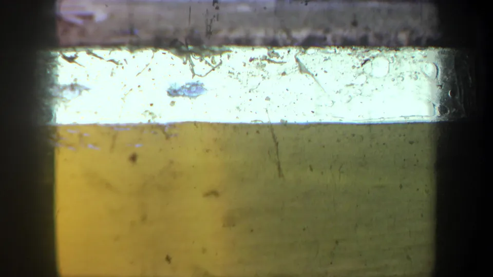 A bright exposed band and yellow-green ground or bank appear in this soft 8mm frame from the 1957 Oregon-associated clip.