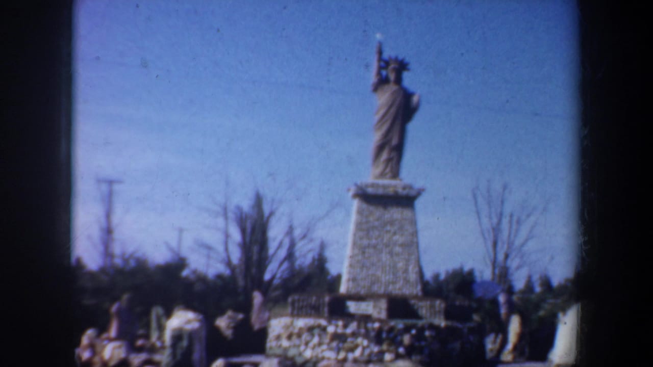 Small Statue of Liberty model on a pedestal at an outdoor miniature display.