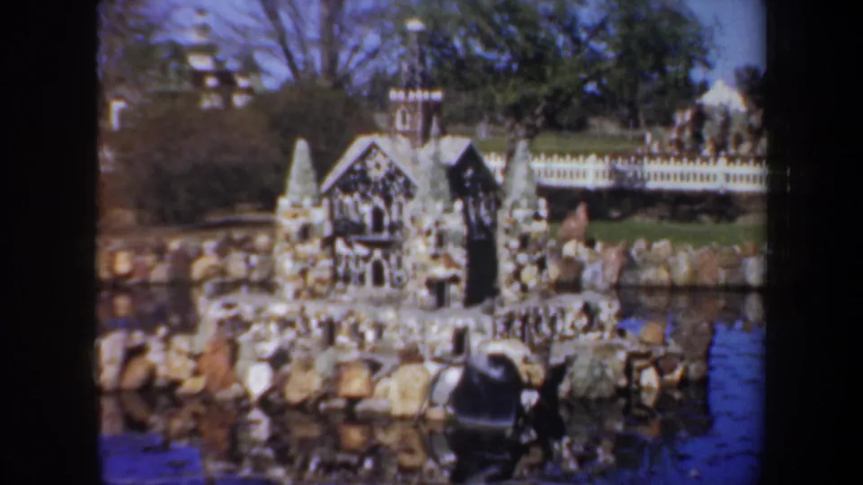 Miniature stone structures, rocks, water, and visitors appear within the Portland landmark setting captured on 8mm film.