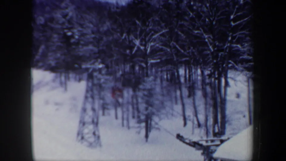 Wide 8mm view of a snowy New Hampshire wooded slope, with the red tracked vehicle small and partly obscured.