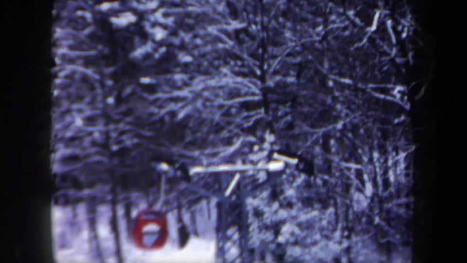 1962 New Hampshire 8mm frame showing a red ski-lift gondola moving through snow-covered forest.