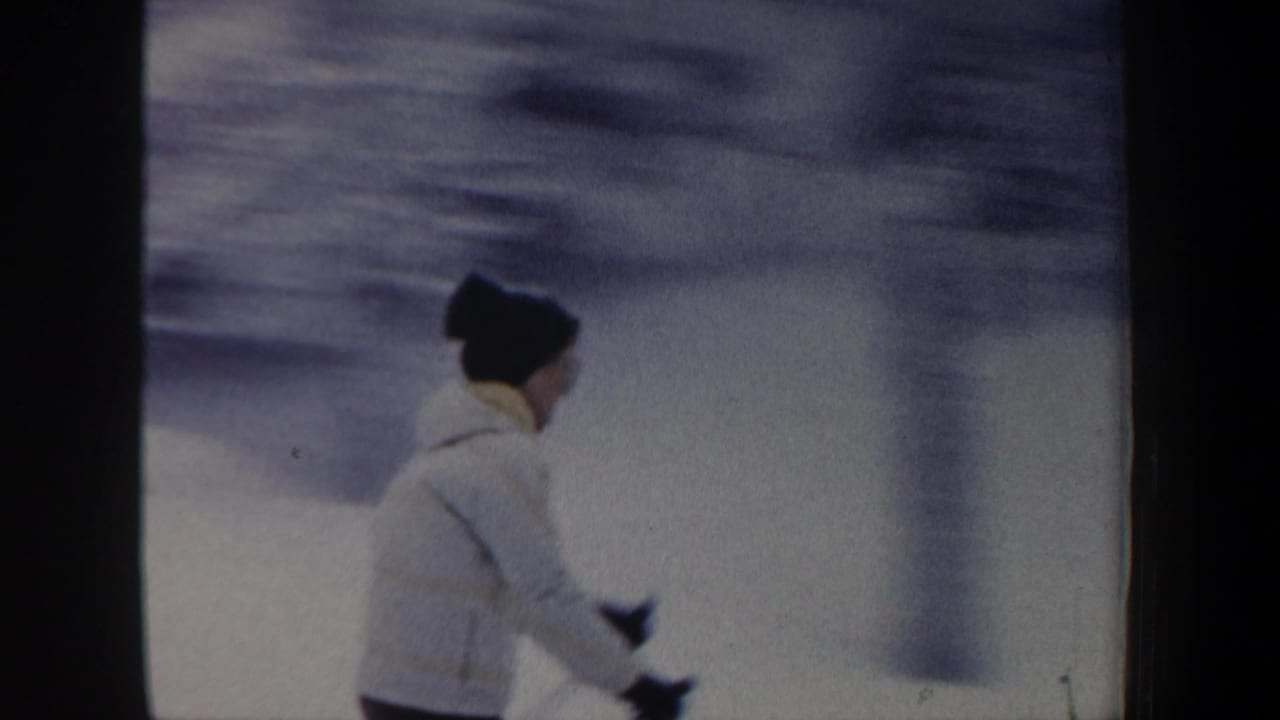 Side view of the skier passing across a snowy hillside.