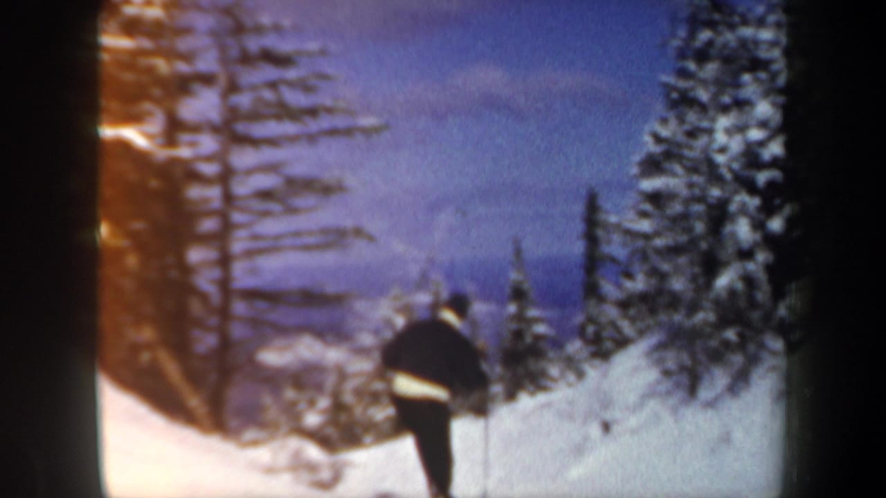 A lone skier descends a snowy New Hampshire slope in 1962, filmed from a fixed 8mm home-movie viewpoint.