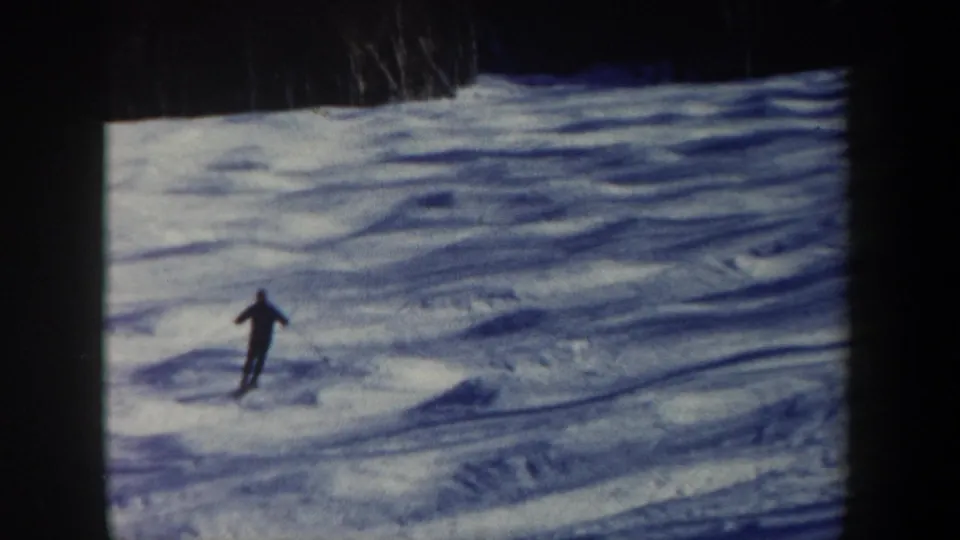 The skier appears near the center of the snowy New Hampshire slope, filmed at a distance in soft 1962 8mm color.