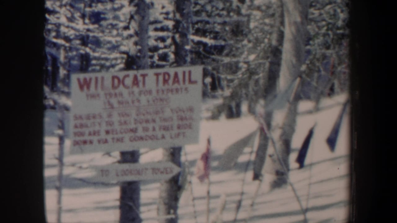 Another close home-movie view of the Wildcat Trail sign in New Hampshire snow, with trees and trail information visible.