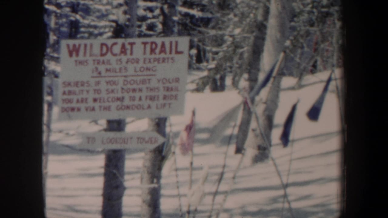 1962 New Hampshire 8mm frame showing a Wildcat Trail sign warning skiers on a snowy wooded slope.
