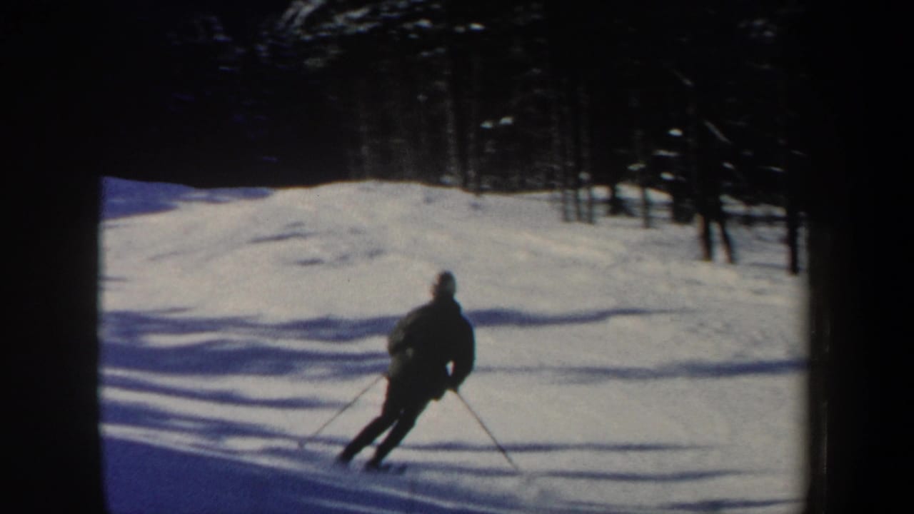 The skier appears farther down the New Hampshire slope, leaning into a turn with poles extended on the snow.