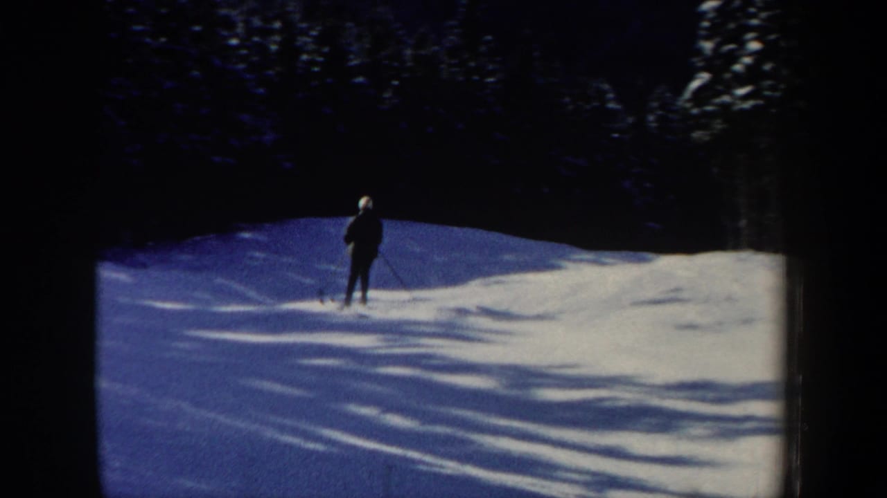 A lone skier in dark clothing and a light hat appears on a snowy New Hampshire slope in 1962 home-movie footage.