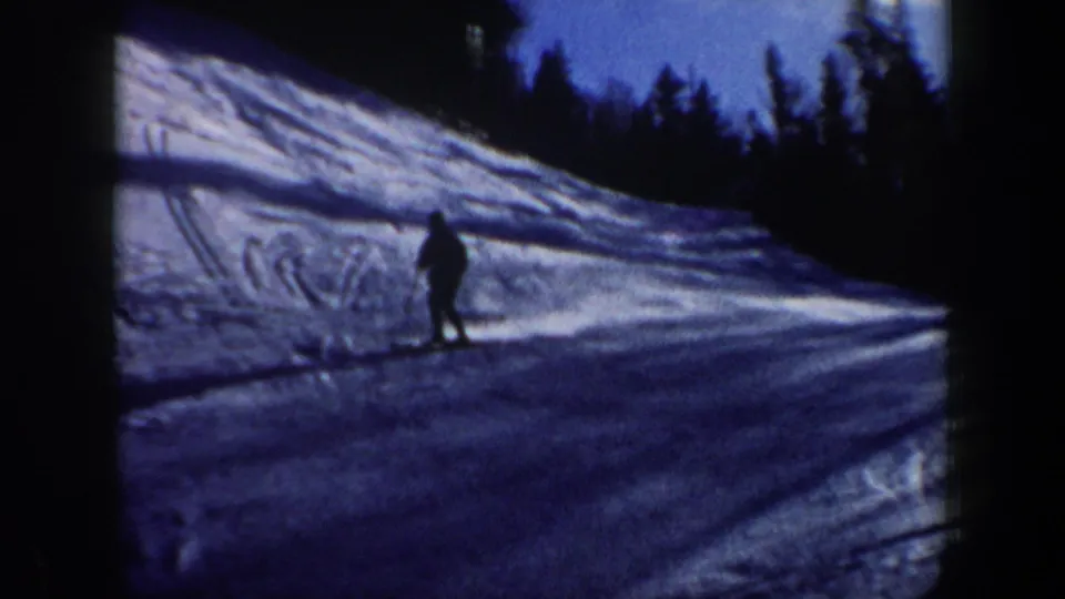 A lone skier nears the lower part of the slope in soft 8mm footage from 1962 New Hampshire.