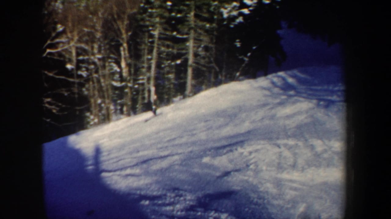 1962 New Hampshire 8mm still showing the skier partly near the forest edge on a snow-covered slope.