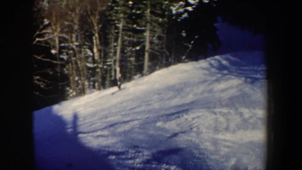 1962 New Hampshire 8mm still showing the skier partly near the forest edge on a snow-covered slope.