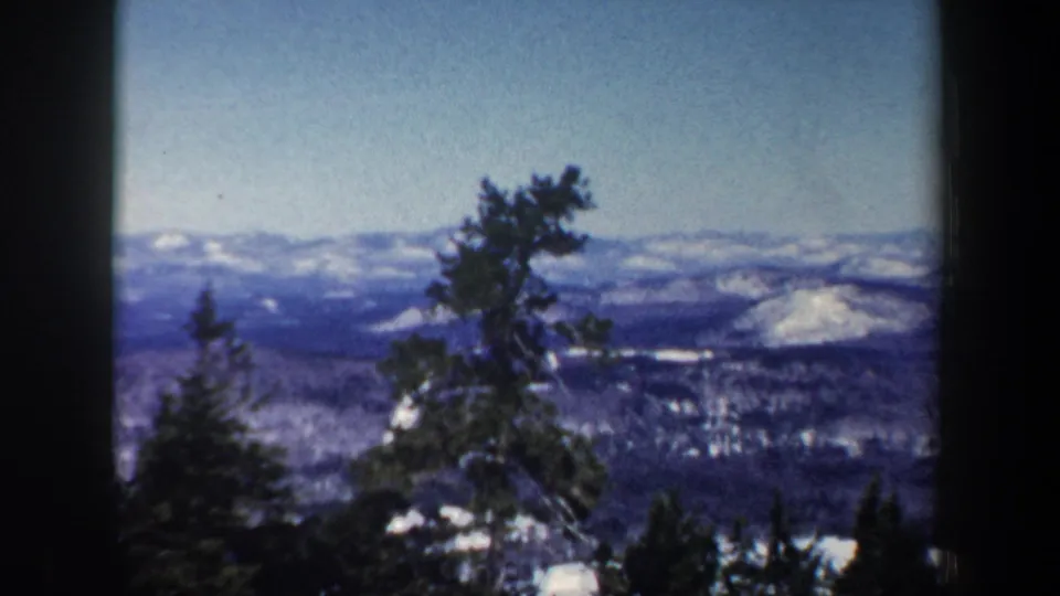 Late-frame view from the 1962 New Hampshire pan, with dark pines silhouetted before snowy ridgelines.