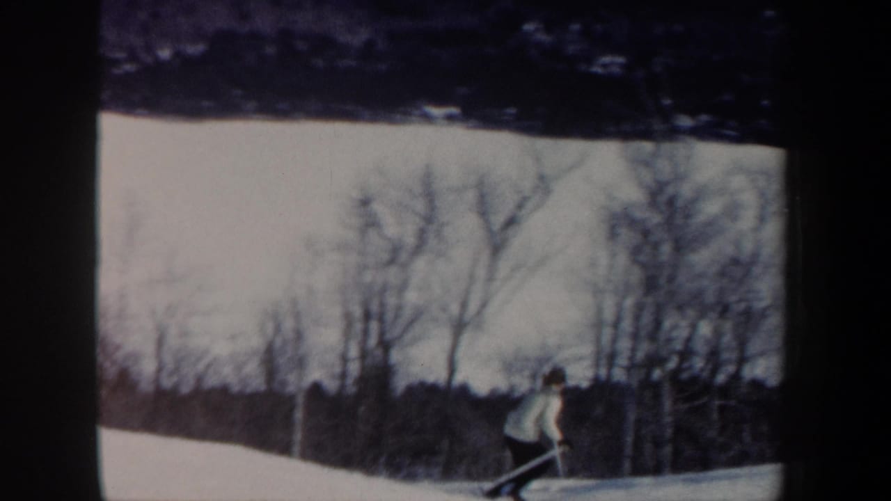 Skier in a light shirt moving across a snowy slope.