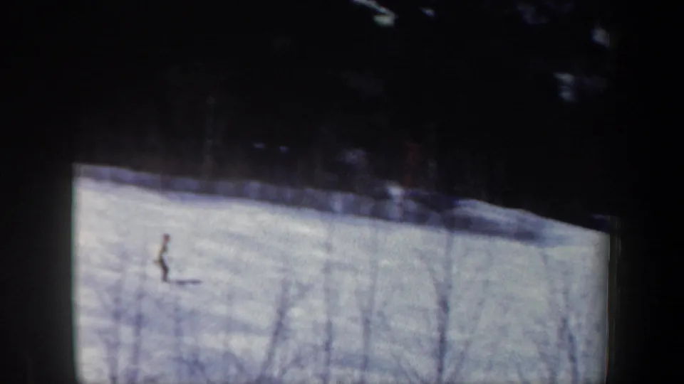 Distant skier on a broad snow-covered New Hampshire hillside, captured in soft 1962 8mm color.