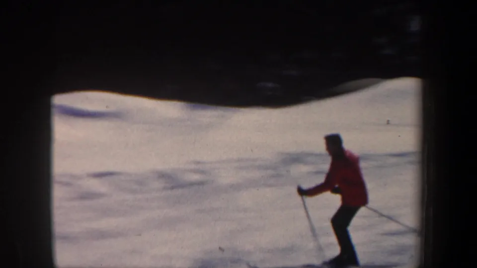 A skier in a red jacket moves across a snowy New Hampshire slope in this 1962 8mm home-movie frame.