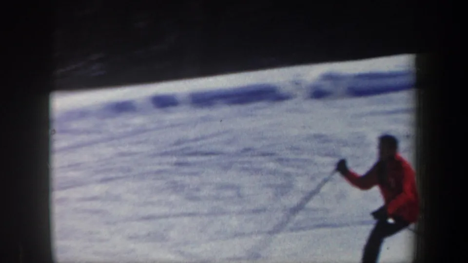 A closer 1962 New Hampshire 8mm frame shows the skier in red holding poles against a textured snowy slope.