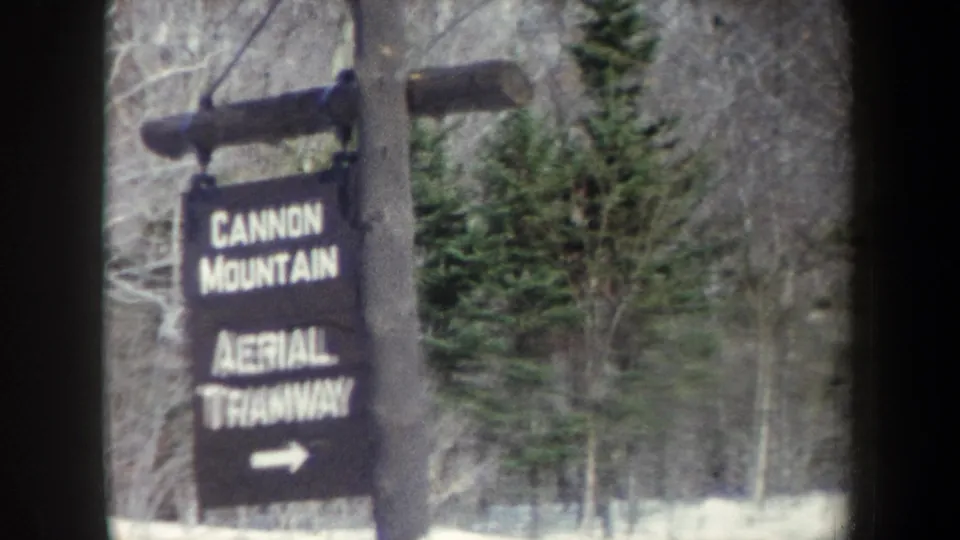1962 8mm frame with the tramway sign and arrow still visible, softened by motion blur and film grain.
