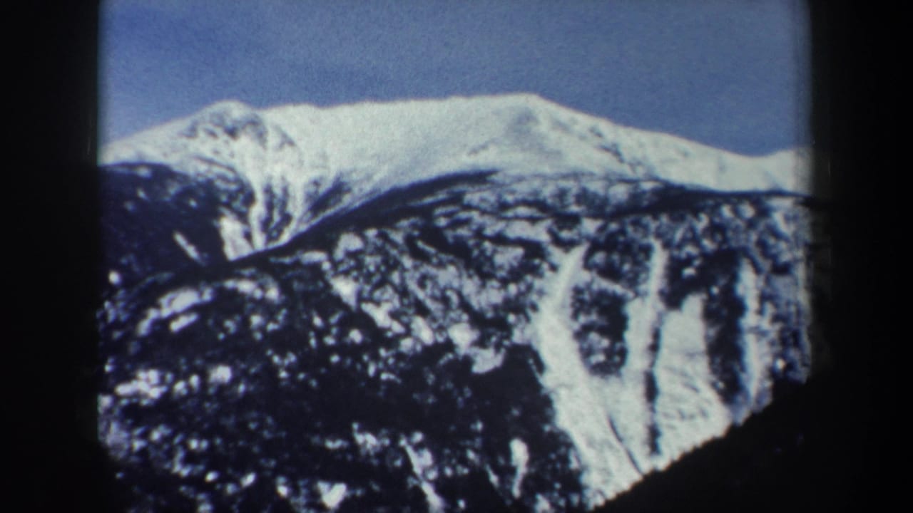 Snowy mountain peak and ridge line framed by dark film borders.