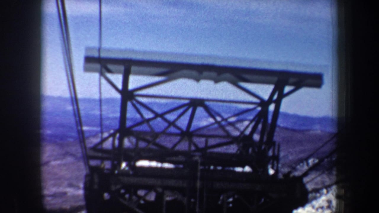 1962 New York 8mm frame showing a steel lift support and cables from a moving mountain cable car viewpoint.