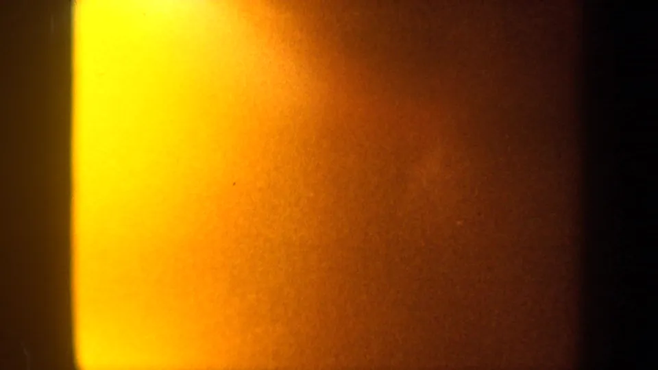 1962 New York 8mm frame with bright yellow-orange exposure bloom, soft vertical borders, and visible film grain.