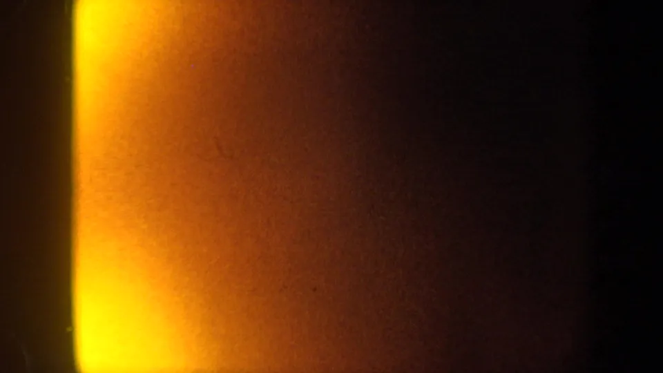 1962 New York 8mm frame showing yellow-orange flare and dark shadow divided by a soft vertical edge.