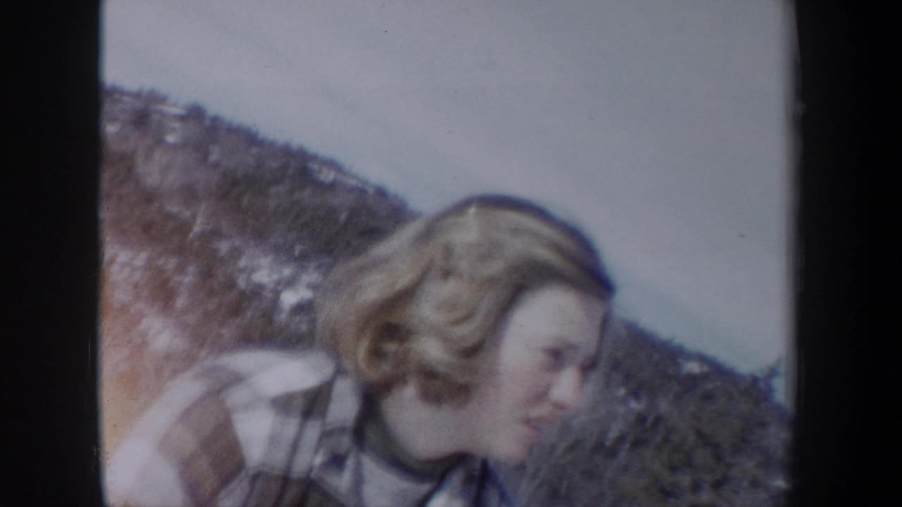 A blonde woman in plaid is seen in profile outdoors in the supplied New York winter home-movie setting.