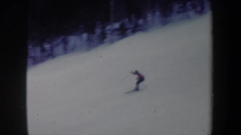 1962 New York 8mm frame showing the distant skier bending slightly during the downhill descent.