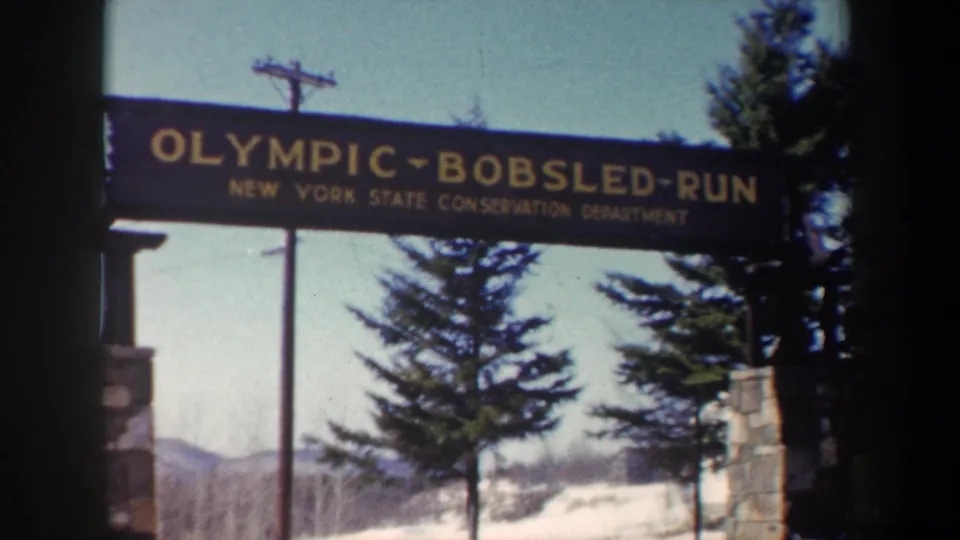 1962 New York frame showing the Olympic Bobsled Run sign and New York State Conservation Department text over a snowy wooded entrance.