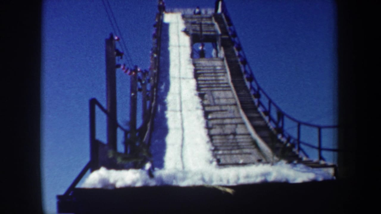1962 New York frame showing the steep upper ramp, snow track, wooden slats, side railings, and small figures near the top.