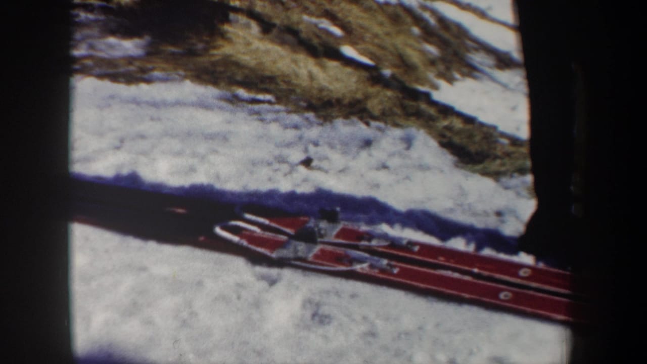 1962 New York 8mm frame showing red skis resting on snow, partly obscured by dark film or frame edges.