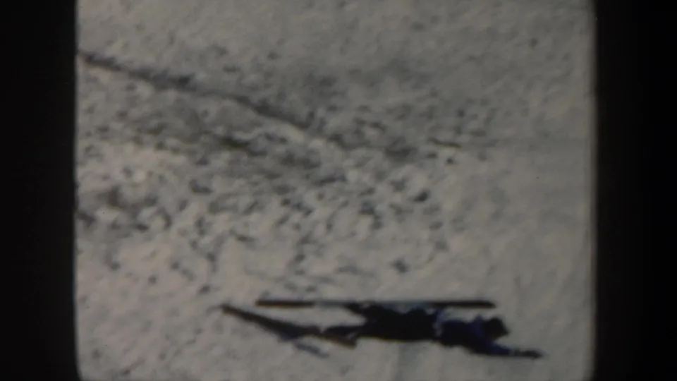 The skier is still down on the snowy slope in this 1962 New York home-movie frame, with visible 8mm grain and gate shadow.