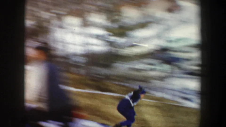 A blurred figure moves through the winter scene, with snow patches and strong handheld motion in the 1962 New York 8mm footage.