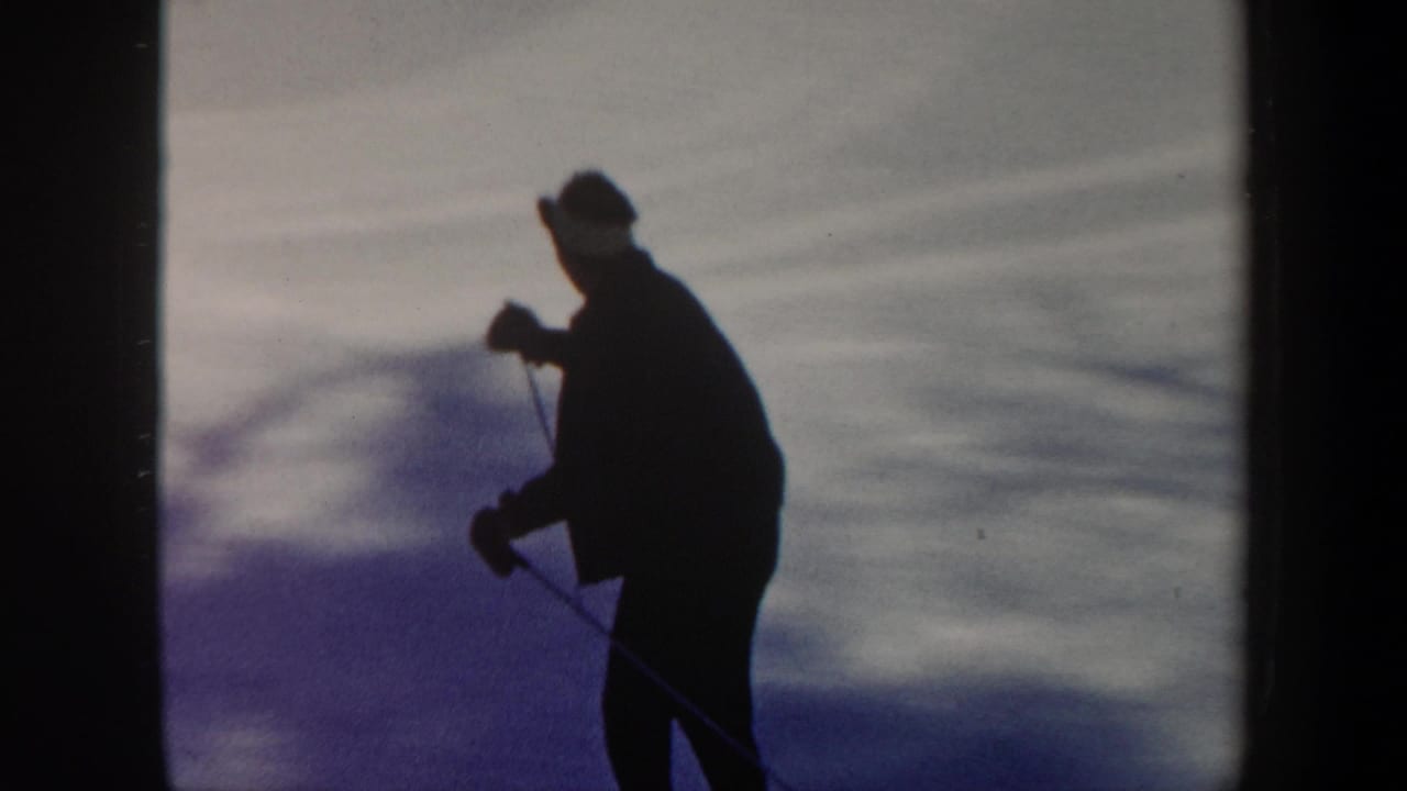 1962 Vermont 8mm frame showing a skier in dark clothing on a snow-covered slope, partly silhouetted by winter light.