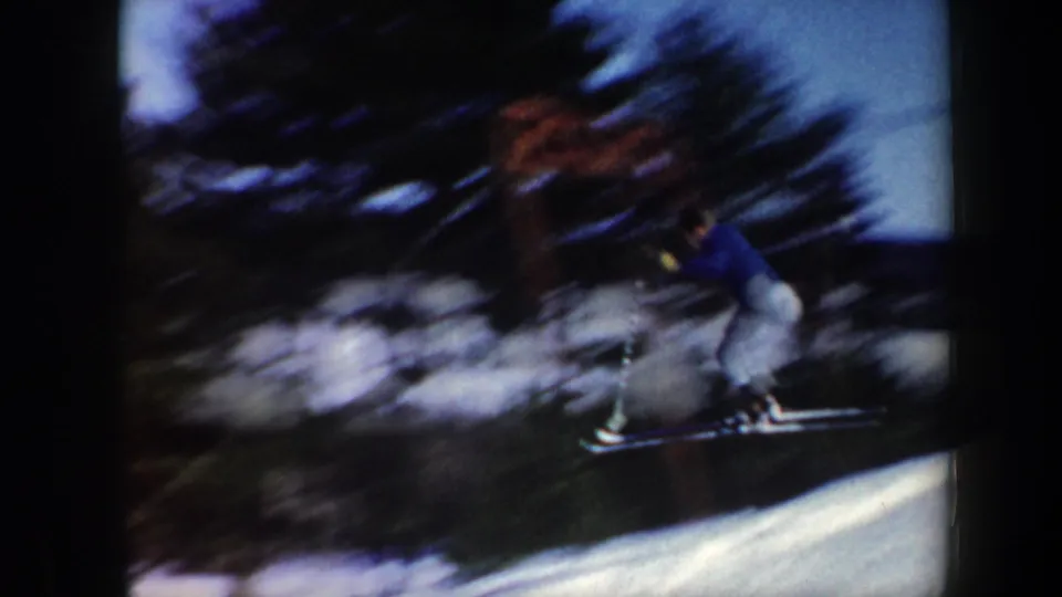 A closer, motion-blurred view shows a skier passing near trees on a snowy Vermont incline, emphasizing the speed and handheld home-movie capture.