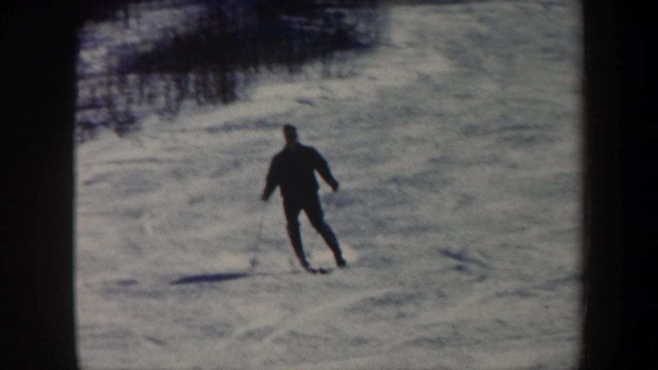 Skier continues across the slope, leaning slightly on the snow.