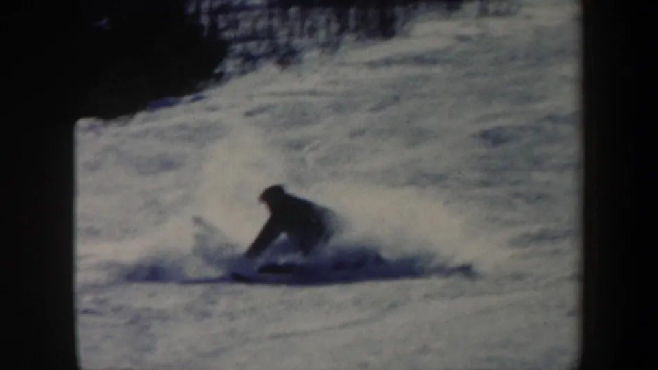 1962 Vermont home-movie frame showing the skier down on the snowy slope during a fall.