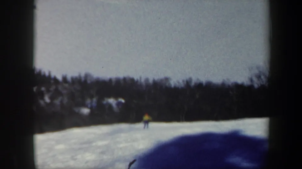 Near the end of the clip, the skier is small in the center of the snowy Vermont slope, backed by a dark winter tree line and soft 8mm color.