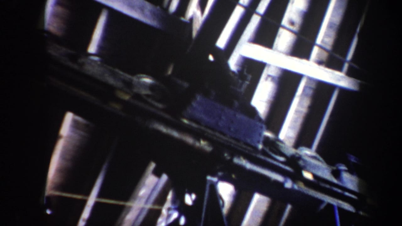 Ski lift hardware fills the frame with bright metal rods and dark moving parts.