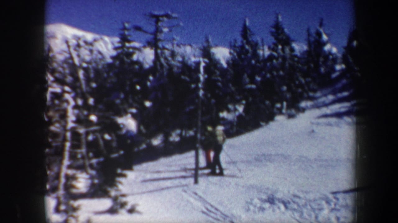 1962 Vermont 8mm frame showing a snowy ski slope, evergreens, mountains, and small figures near a lift pole.