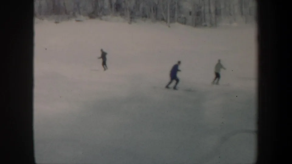 Several skiers move across a snowy Vermont hillside in a brief 1962 8mm home-movie moment.