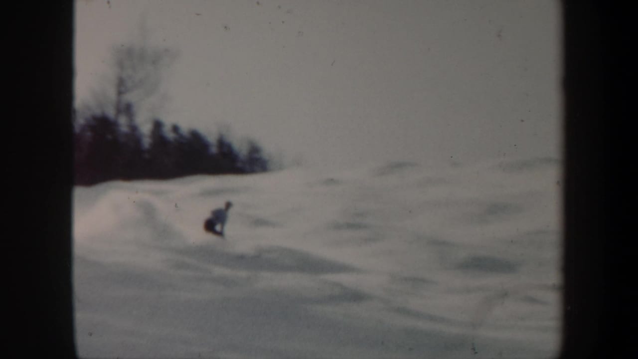 A distant skier moves down an open Vermont ski slope in soft 8mm winter footage from 1962.