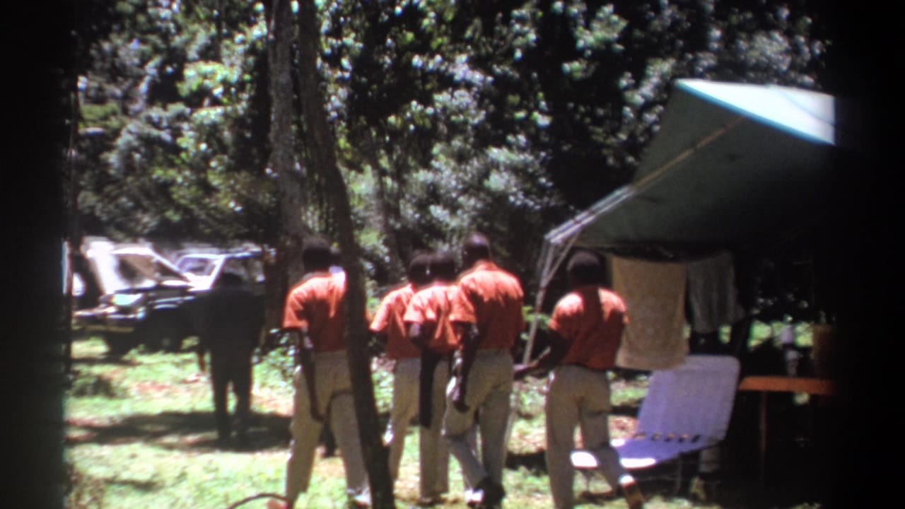 The final frame shows the group gathered farther from the camera near the tent, with a vehicle and wooded campground still visible.